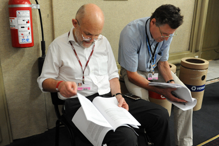 Delegados lêem documentos nos corredores do centro de convenções (foto: IISD.ca)