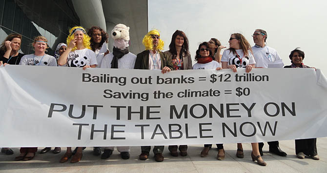 Manifestantes reclamam dos trilhões dados para salvar os bancos da crise financeira e dos centavos que chegam para mitigar as mudanças climáticas. Foto: Nathália Clark