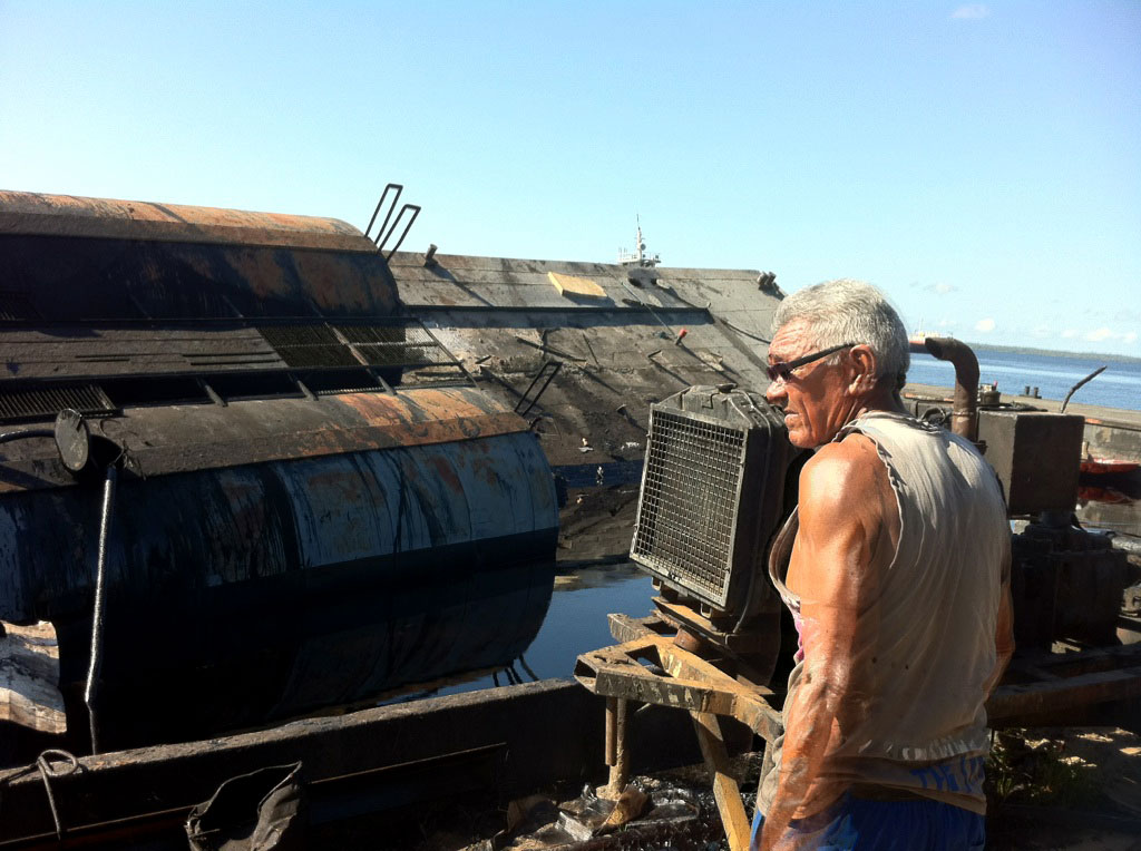Operário da empresa acompanha retirada do produto dos tanques que ficaram na balsa.