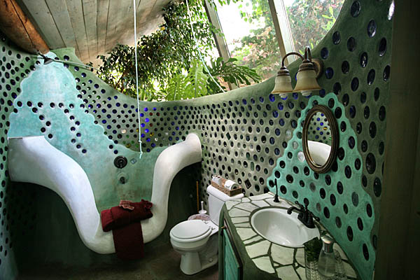Banheiro da “Earthship” Phoenix usa paredes de adobe e garrafas de vidro. A água usada nas pias e no banho é reutilizada na descarga e depois tratada na própria casa.