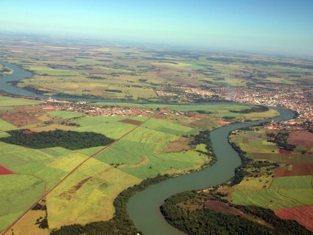 Fotografia aérea do rio Paranaíba, na divisa de Itumbiara (GO) e Araporã (MG). Projeto de lei pioraria a paisagem, tomada pela produção agrícola. Foto: wikimédia. 